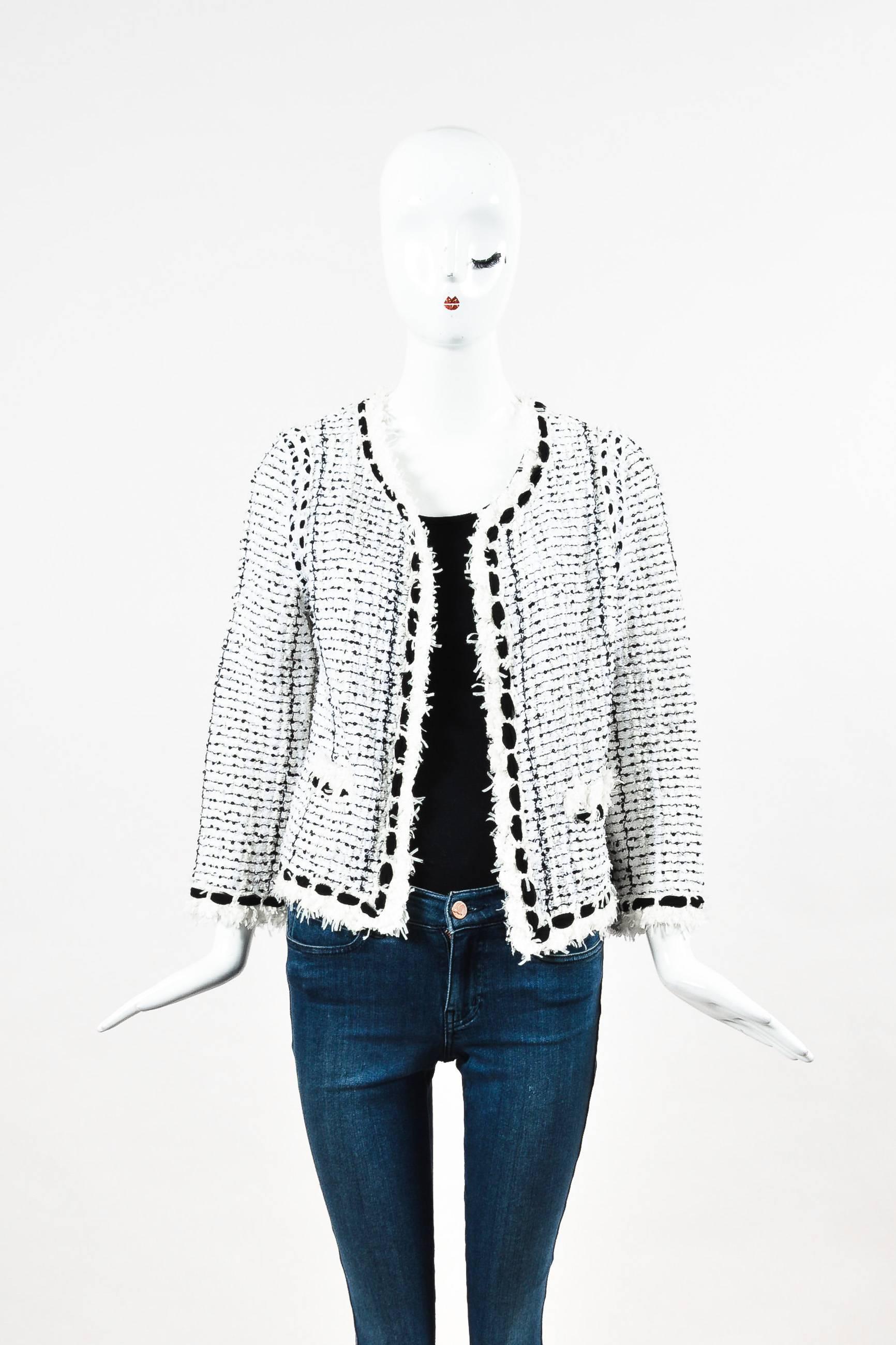 Style this Chanel jacket with a black pencil skirt and captoe pumps for a timeless look. White boucle tweed embellished with black sequins and silk chiffon. Frayed trim. V-neckline. Concealed hook-and-eye fastening. Slot pockets. Left pocket