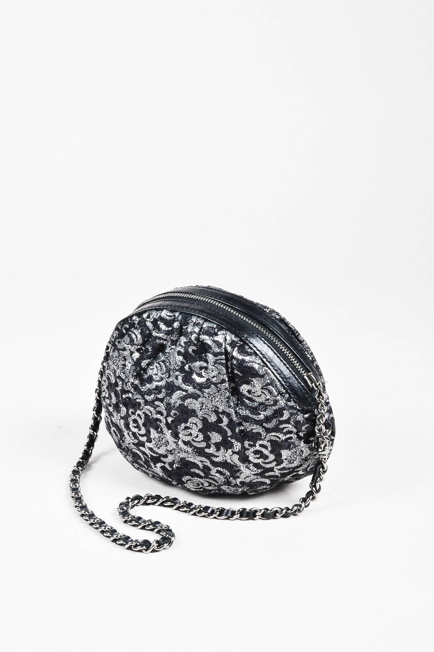 Chanel black jacquard pouch designed with a silver-tone metal chain strap. Leather trim runs along zip top closure. A sweet departure from the brand's signature offering. Serial #:9017274. Circa 2004-2005.

Measurements:
Height: Approximately
