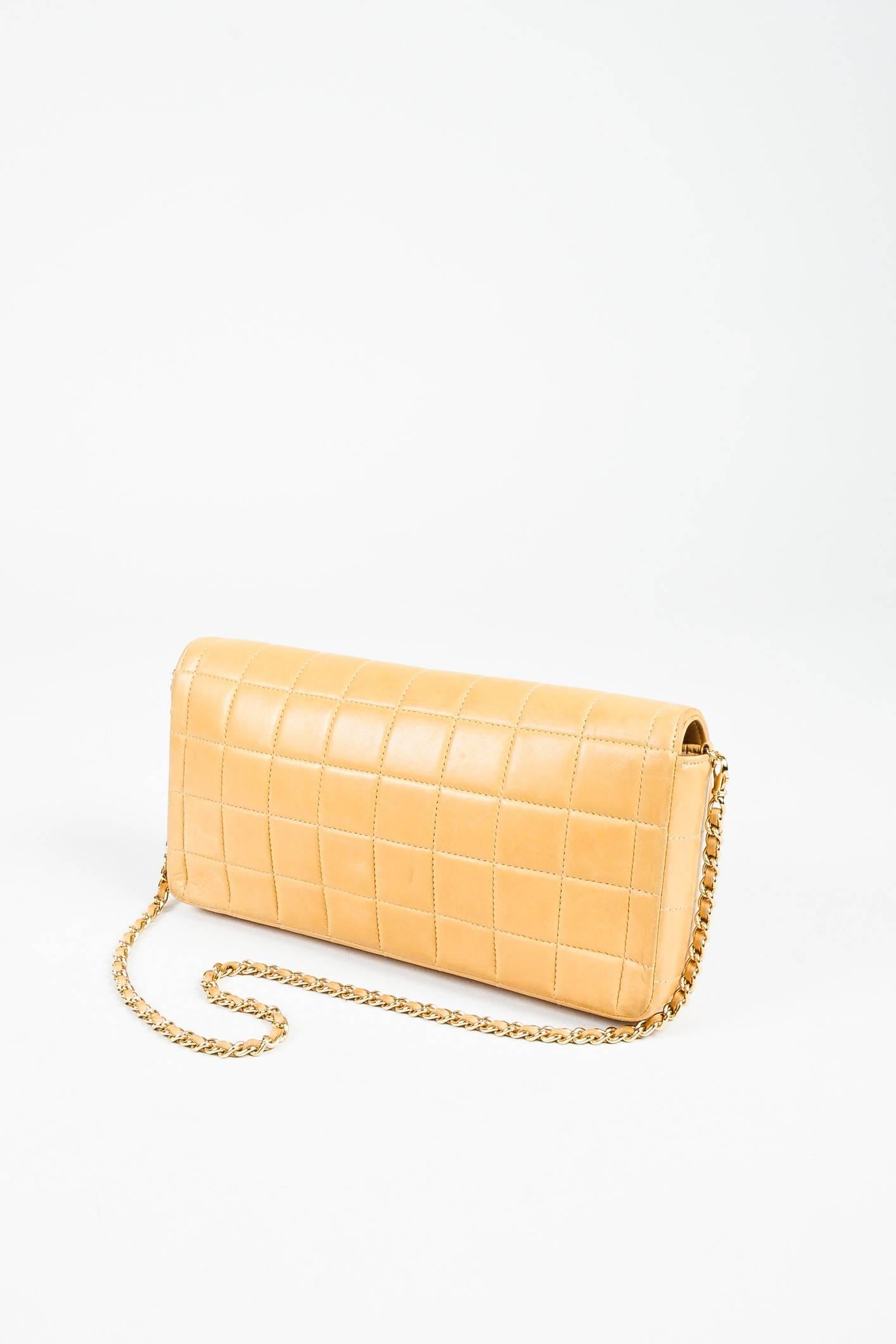Chanel quilted leather "East West Chocolate Bar" bag. Features a gold-tone metal chain strap with matching leather woven through each loop. "CC" logo rotating lock closure. Lined with leather.

Interior features: Two open top