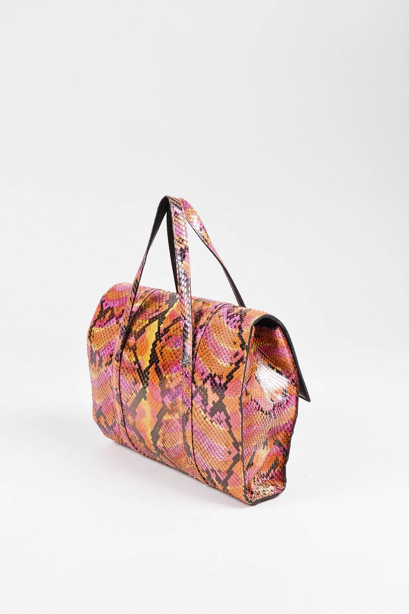 This bag may be small, but packs a bold punch. Luxurious python snakeskin construction. Unique multicolored pattern. Clear plastic 'CC' logo applique at front. Top flat handles. Front flap with hidden magnetic closure. Open interior. Comes with dust