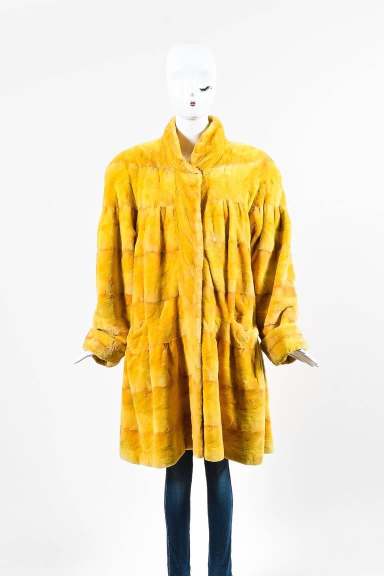 Color: Yellow,
Made In: Unknown.
Fabric Content: Genuine Sheared Mink
Item Specifics & Details: Plush genuine sheared mink fur construction. High collar. Long sleeves. Side slit pockets. Padded shoulders. Hidden front hook-and-eye closure.