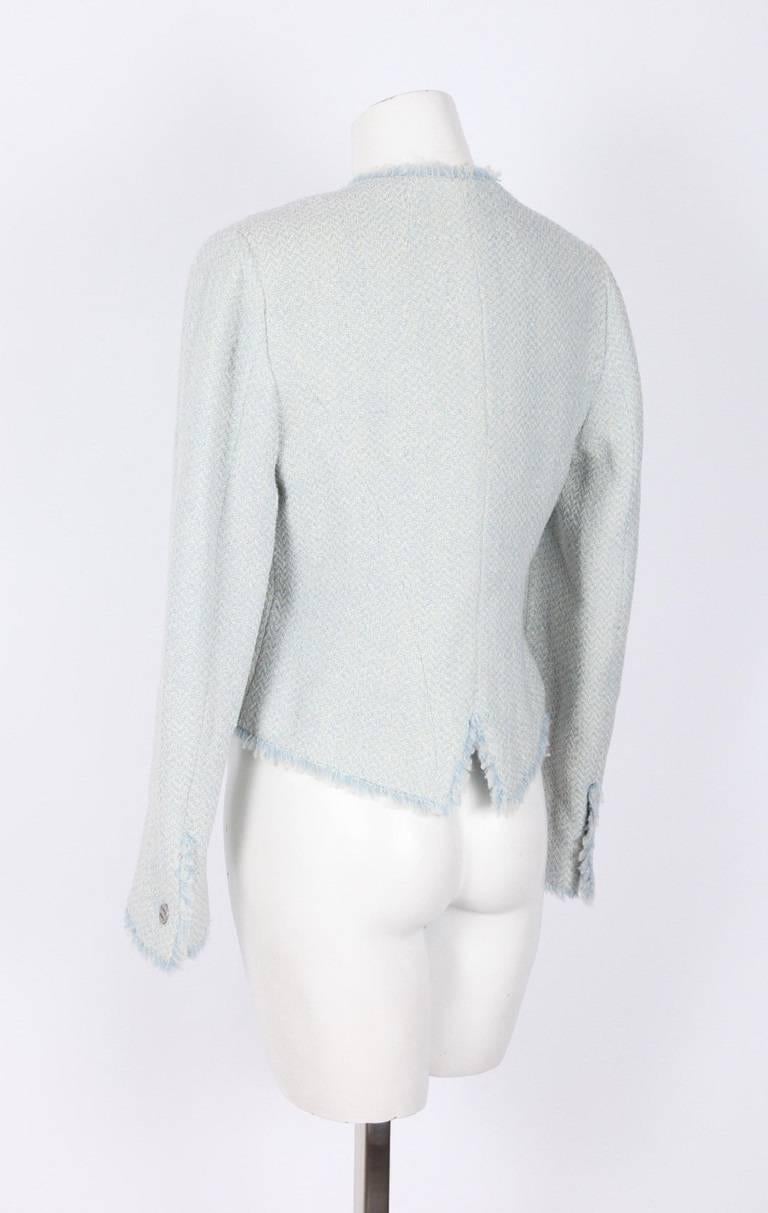 *Blue and cream knit with a slight silver sparkle
Sleeves have a single silver button and fringe at openings
Buttons down front are silver and read "CHANEL PARIS"
Thin silver chain trim around interior hemline
Blue and cream fringe around