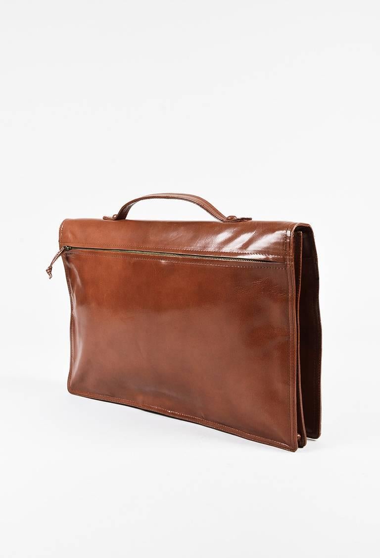 Color: Brown,
Made In: Italy
Fabric Content: Leather; Lining: Textile

Item Specifics & Details: Brown leather double flap briefcase bag from Bottega Veneta circa 1990s. Top handle for wear. Large zip pocket on the back. Inner snap closure at the