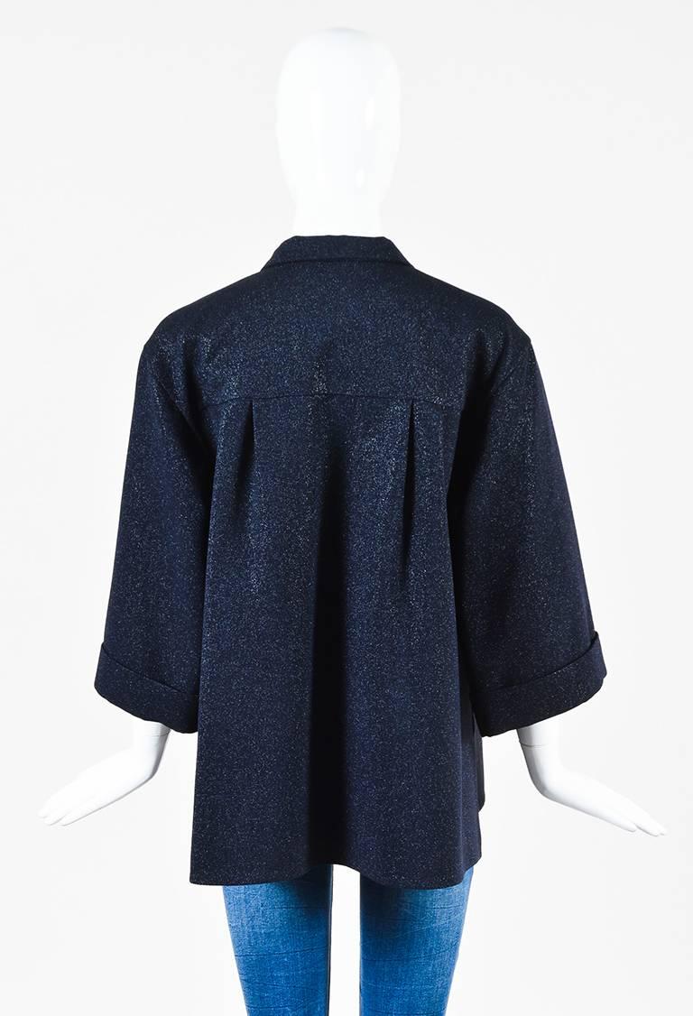 Size: 42 (FR)
Color: Blue,
Made In: France
Fabric Content: Wool, Nylon; Lining: Wool, Nylon
Item Specifics & Details: Metallic navy wool blend long sleeve tie neck jacket from Chanel. Wide cut sleeves hit slightly above the wrists. Ribbed trim.