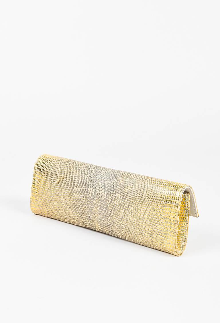 Color: Gold,
Made In: Italy
Fabric Content: Genuine Lizard, Leather

Item Specifics & Details: Metallic gold genuine lizard clutch bag from Chanel circa 2003-2004. Front flap. Two decorative gold-tone chain link details at the front with faux