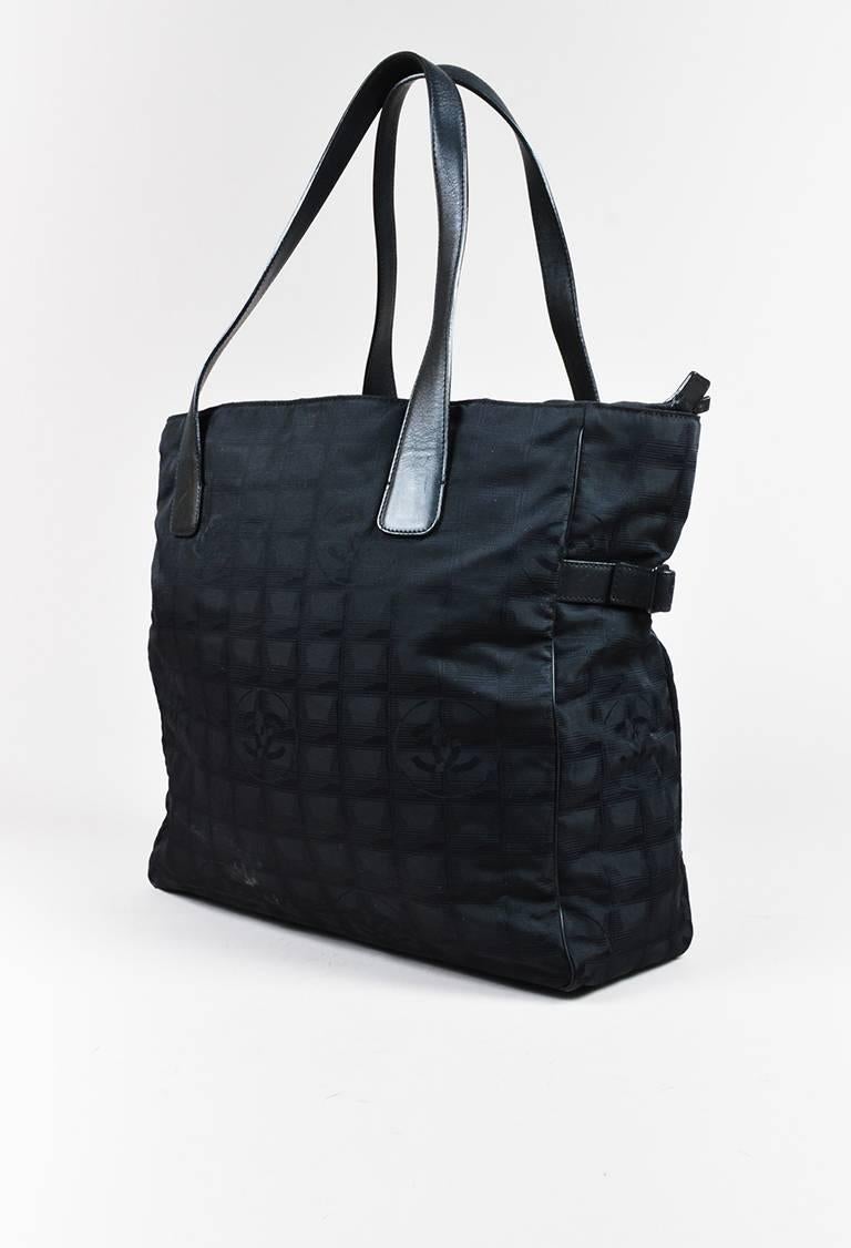 Color: Black,
Made In: Italy
Fabric Content: Nylon, Leather; Lining: Nylon
Item Specifics & Details: Black 'CC' printed nylon and leather trim tote bag from Chanel's Travel Line circa 2003. Buckled straps on the upper sides. Two handles for