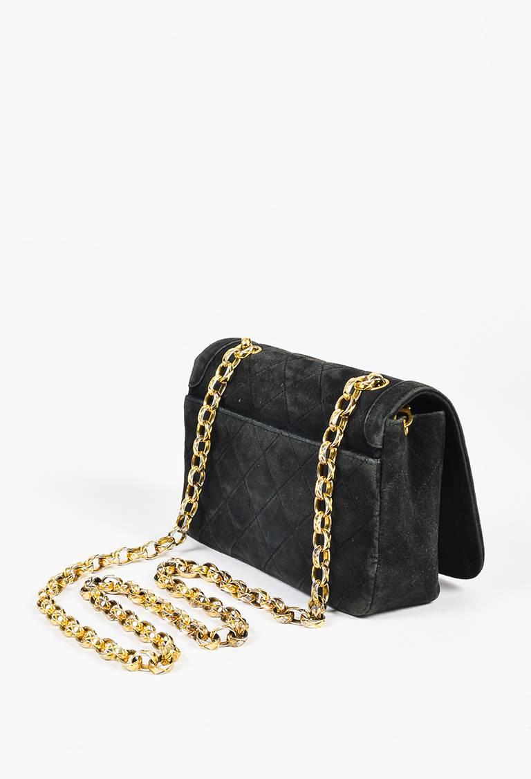 Color: Black,
Made In: France
Fabric Content: Suede; Lining: Leather
Item Specifics & Details: Black quilted suede shoulder bag from Chanel circa 1986-1988. Front flap with a gold-tone 'CC' turn lock closure. Open pocket on the back. Gold-tone chain