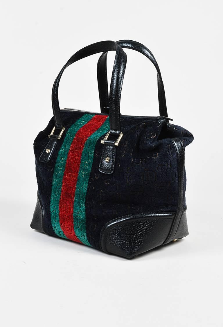 Black and multicolor velvet horsebit print and leather trim "Treasure" Boston bag from Gucci. Five gold-tone bag feet. Two handles for wear. Chain link keychain with a key detail attached to handle. Leather frame with a gold-tone push lock