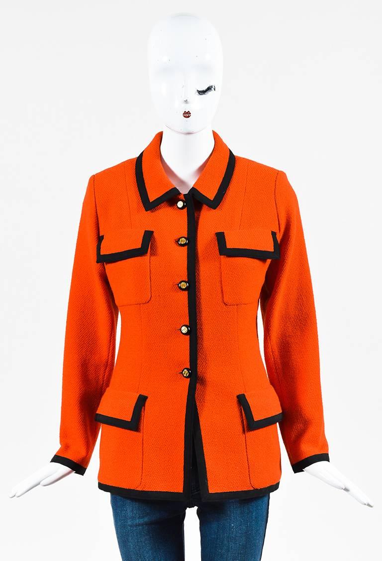 Orange wool and black grosgrain trim collared blazer jacket from Chanel Boutique's Collection 25 circa 1986. Four flap pockets on the front. Black and gold-tone 'CC' buttons down the front for closure. Shoulder pads. Lined.

Size: 40 (FR)
Made in: