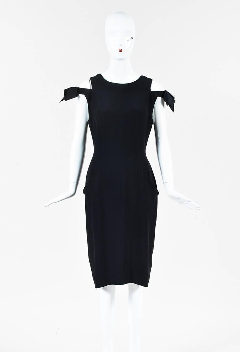 Black crepe cold shoulder sleeveless dress from Chanel Boutique circa 1990s. Bow detail on the upper arm. Rounded neckline. Two open pockets on the front. Back invisible zipper and hook and eye for closure. Lined.

Size: 38 (FR)
Made in: