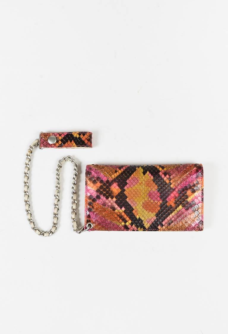 Python snakeskin change purse featuring a a flap front with a transparent 'CC' detail at front, hidden snap closures, and an interwoven chain-leather attachment with a lobster clasp and snapped tab. Interior features three open compartments, a card