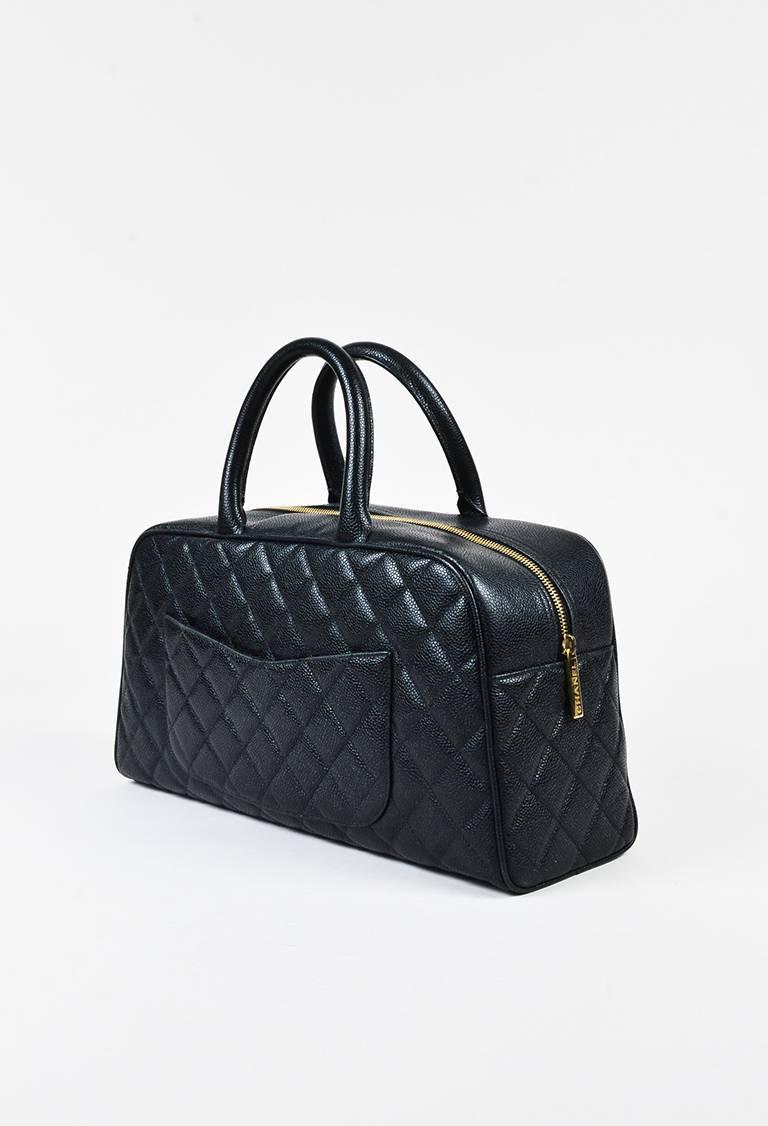 Caviar leather bowler bag featuring dual rolled top handles, a gold-tone top zip closure, iconic quilting, an interlocking 'CC' stitch at front, curved back pocket, and a footed seat. Released circa spring 2003. Serial #: 8211265. Comes with box and