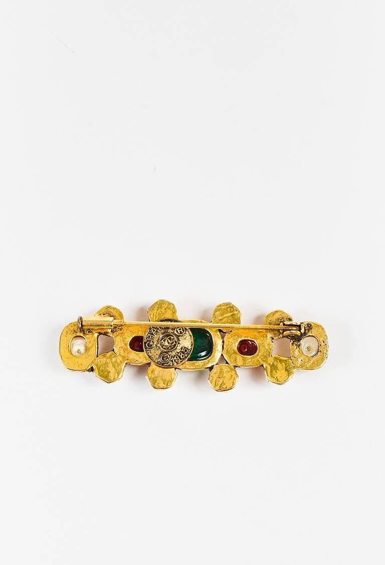 Gold-tone hardware. Multicolored gripoix glass stones. Cabochon pearl accents. Crystal detail. Back pull-push clasp closure.

Made in: Unknown.
Color: Red, Green, Gold
Content: Metal, Faux Pearl, Gripox, Crystal
Condition: Pre-owned. Appears back