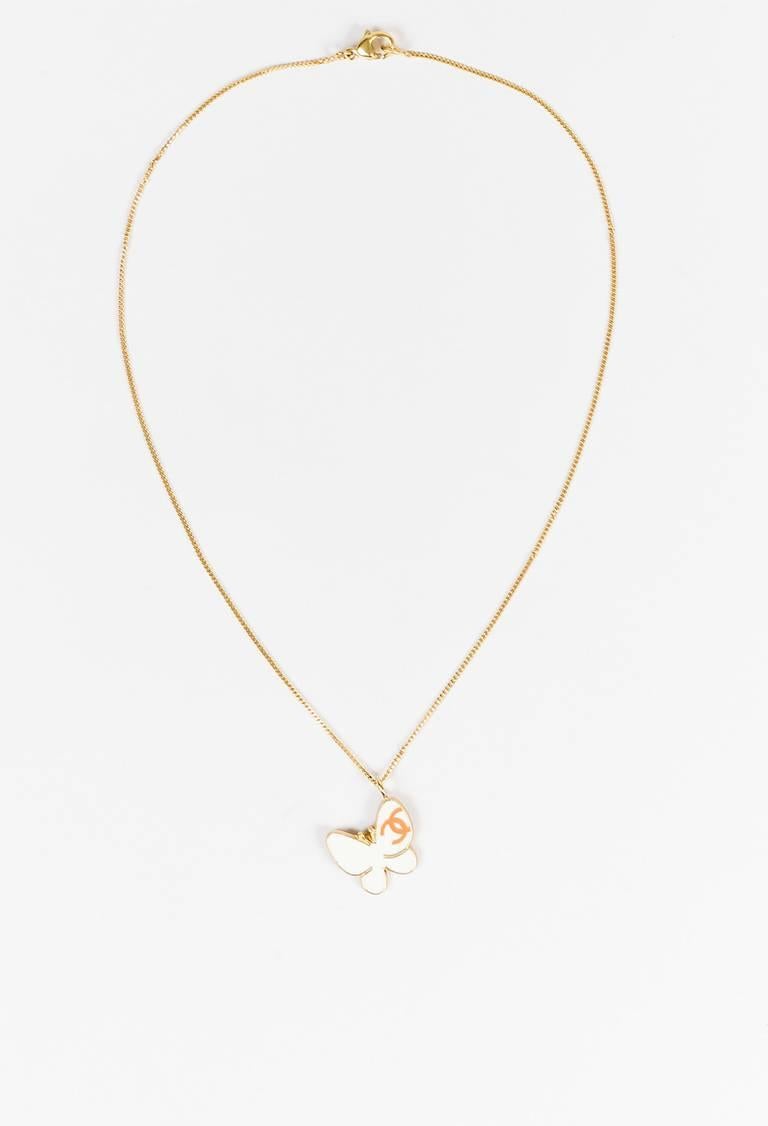 Gold-tone metal chain link and cream enamel butterfly shaped pendant necklace from Chanel circa Spring 2007. Light coral 'CC' logo on the pendant. Lobster clasp closure.

Size: N/A
Color: Gold,
Made in: France
Fabric Content: Gold Tone Metal,