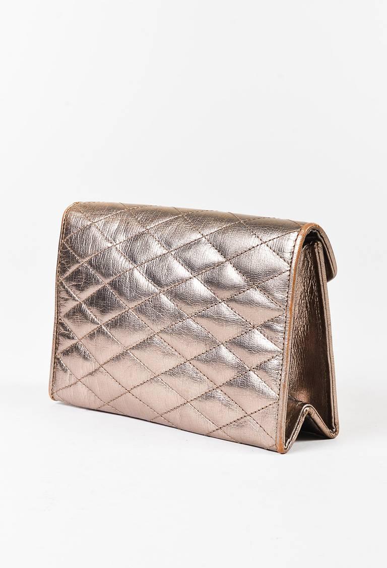 Metallic gold quilted leather clutch bag from Chanel. Front flap with a concealed snap closure. Gold-tone 'CC' logo on the front of the flap. Satin interior lining features a zip pocket and an open pocket. Comes with dust bag.

Made in: Italy
Color: