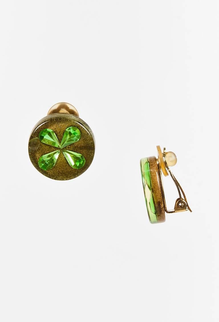 Resin earrings featuring green crystals in a clover motif, gold-tone hardware, and a clip-on clasp. From the cruise 2001 collection. Comes with: Box

Color: Gold,Green,Metallic,
Made in: France
Fabric Content: Resin, Crystals, Metal
Condition: