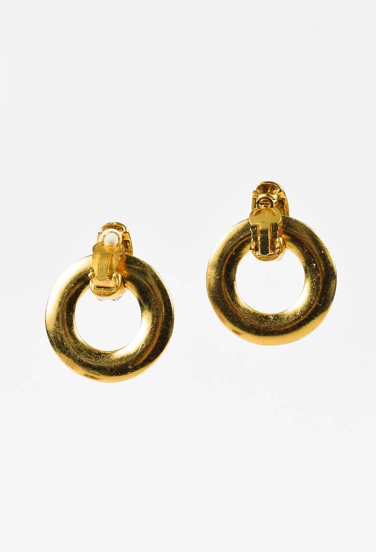 Gold-tone metal hoop earring featuring crystal accents and a clip-on clasp. Released circa 1986, season 23.

Color: Gold,
Made in: France
Fabric Content: Metal, Crystals
Condition: Pre-owned. Missing a cushion at one clasp. Hairline scratches and