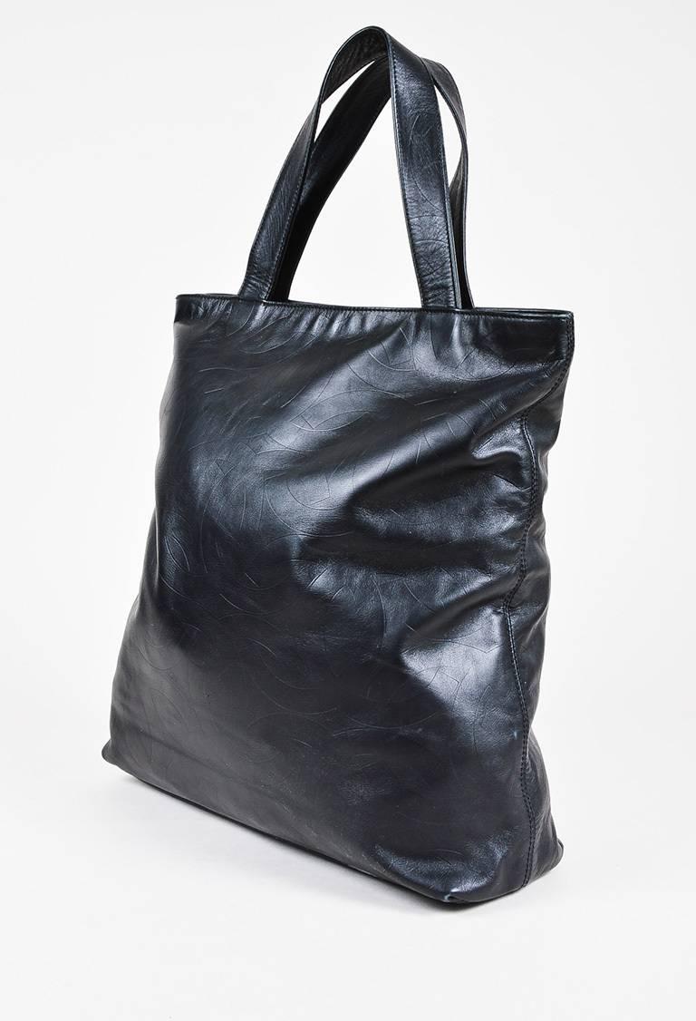Black lambskin leather 'CC' embossed tote bag from Chanel circa 1997-1999. Two handles for wear. Top gold-tone zipper for closure. Interior lining features two zip pockets. Serial #:5981078.

Size: N/A
Color: Black,
Made in: Italy
Fabric Content: