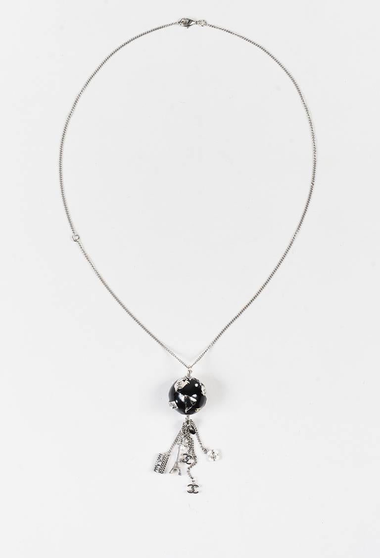 Feel well-traveled wearing this unique necklace from Chanel's 2013 collection. Whimsical globe shaped pedant with Chanel signature accents and a glossy enamel finish. Silver-tone hardware. Curb link chain with playful charms. Lobster claw clasp