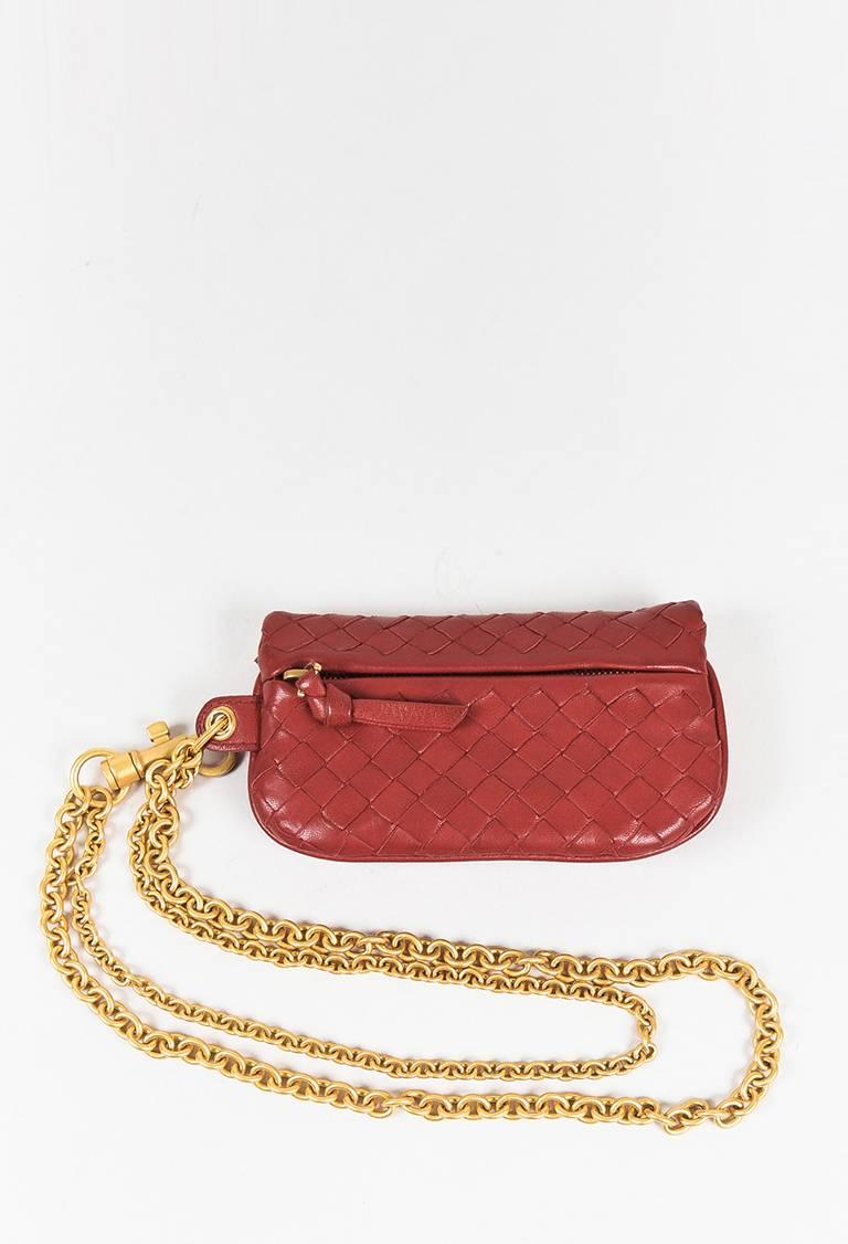 Rare Bottega Veneta coin purse featuring a signature intrecciato leather construction, flap front with a hidden gold-tone snap closure, a zipped back pocket, and a matte gold-tone two-strand chain with a lobster clasp. Interior features two open