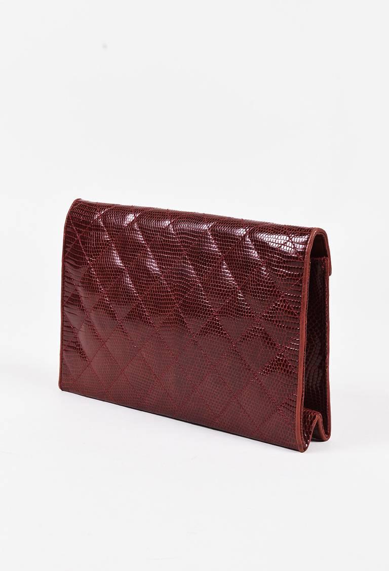 Red genuine lizard asymmetric flap shoulder bag from Chanel circa pre-1986. Interlocking gold-tone 'CC' logo on the front. Flap has a concealed snap closure. Gold-tone chain link strap for wear. Embossed 'CC' logo on the inner side of the flap.