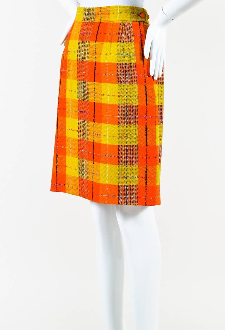 Woolen textile construction. Checkered plaid print throughout. Side slit pockets. Pencil silhouette. Hidden side zip closure and button closure. Lined.

Size: 40 (FR)
Color: Black,Orange,Yellow,
Made in: Unknown.
Fabric Content: Unknown, no