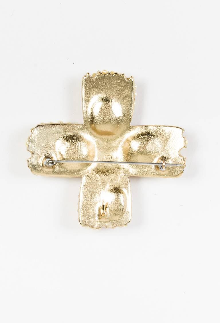 Bold brooch from Chanel's fall 2005 collection. Oversized cross shaped base. Gold-tone metal construction. Faux pearl embellishment throughout with 'CC' logo detail. Back c-clasp closure.

Color: Gold,White,
Made in: France
Fabric Content: Metal,