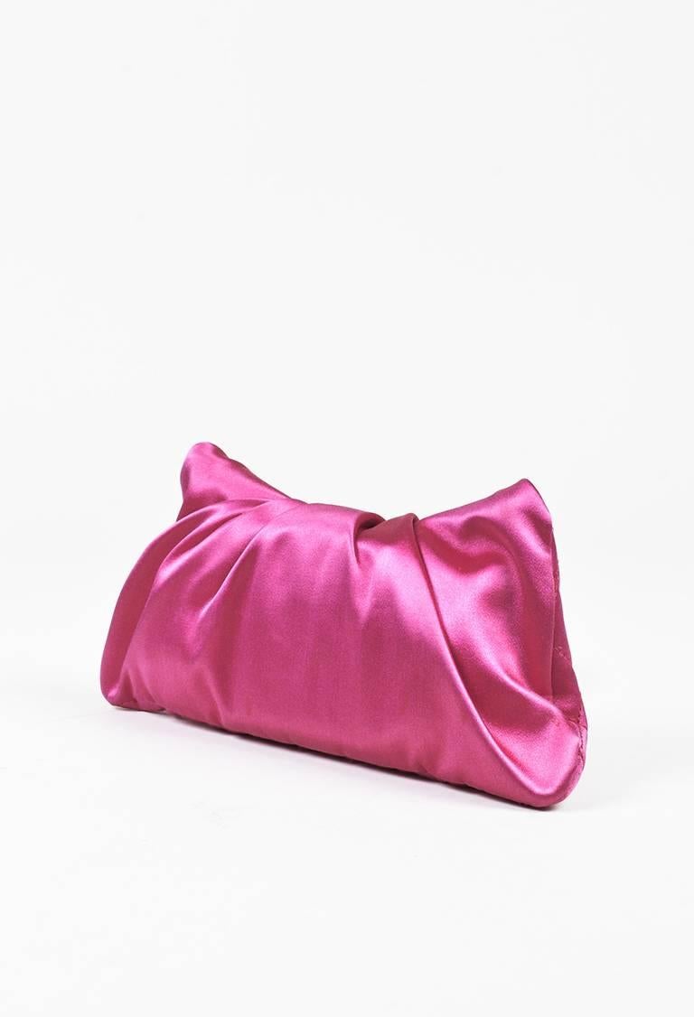 Fuchsia pink evening clutch from Chanel circa 2006-2008. Smooth satin construction. Signature diamond quilted stitching. Flap with a light ruched finish and silver-tone 'CC' logo; fold-over closure. Interior patch pocket. Satin lining. Serial #: