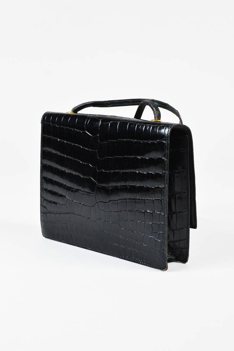 Vintage shoulder bag from Hermes circa 1980 is constructed from glossy, genuine crocodile leather. Front flap with a gold-tone turn lock closure. Open pocket on the front of the bag underneath the flap for additional storage. Single strap for wear.