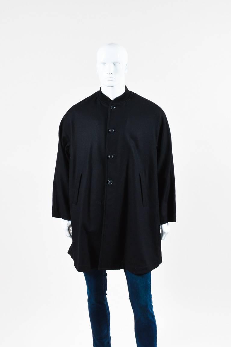 Features a ribbed knit stand collar, a buttoned front, two diagonal front pockets, and a flared silhouette. Unlined.

Size: Small
Color: Black,
Made in: Japan
Fabric Content: Wool, Nylon
Condition: Pre-owned. This item is in good condition.