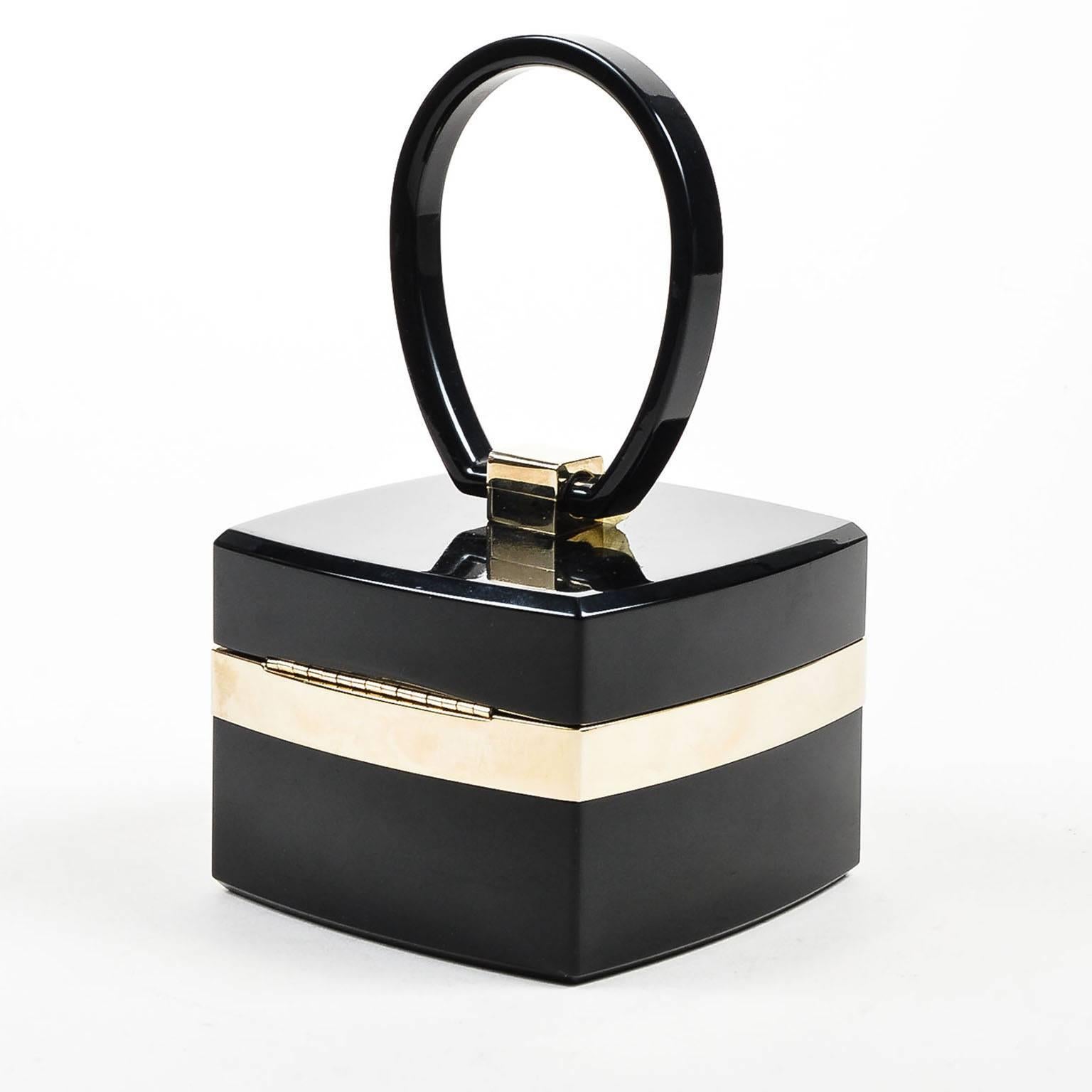 From the Fall 2004 Runway collection, this ultra-rare piece exudes luxury, sophistication, and iconography. With its oval-shaped top handle, golden metallic accents, and iconic 'CC' push-lock closure, this box clutch is a must-have collector's item