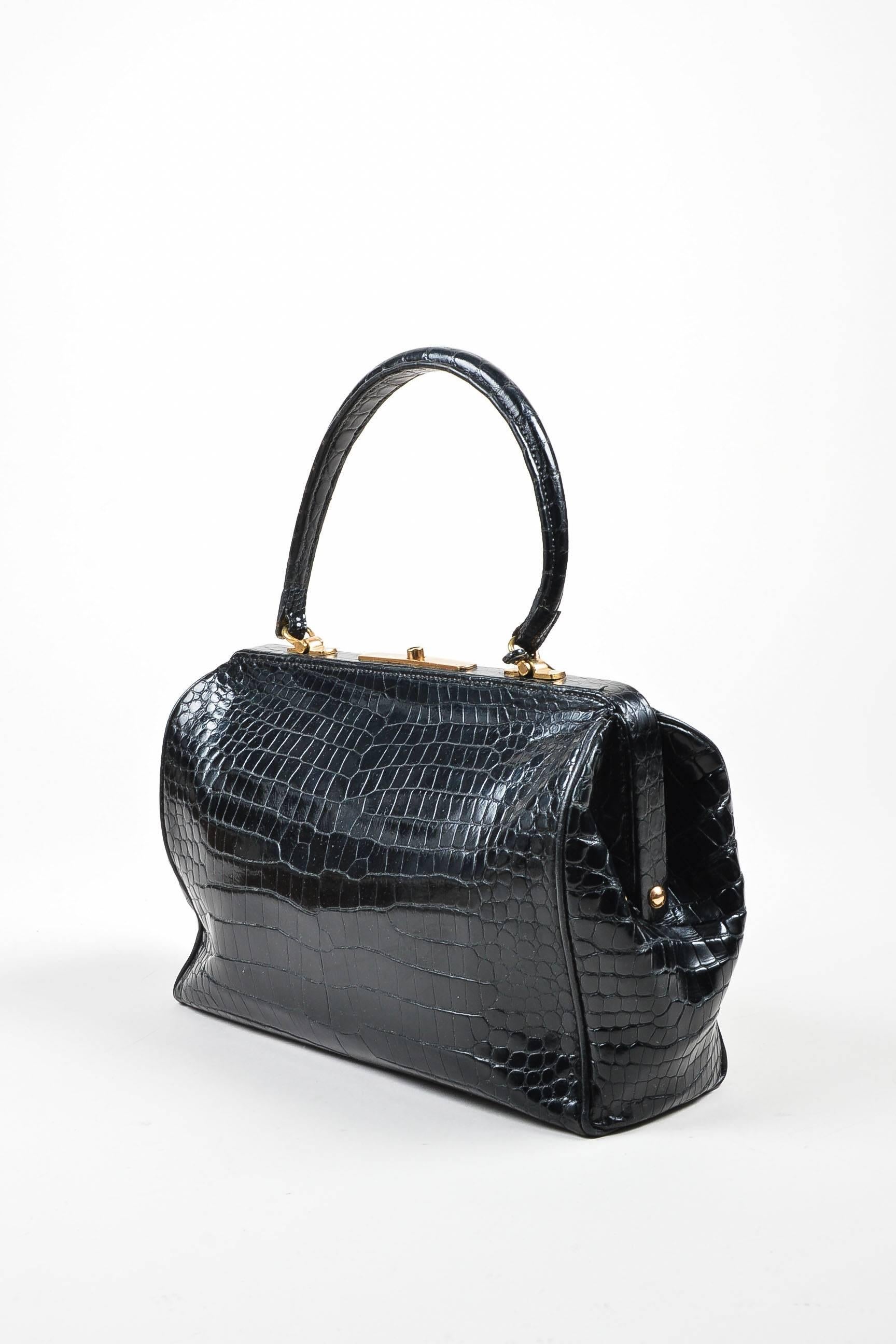 Comes with dust bag. Vintage Hermes satchel handbag. This rare collector's item, designer circa the 1960's, is a stunning addition to any wardrobe. Rectangular shape- resembles the silhouette of an old doctor's bag. Frame structure. Black crocodile