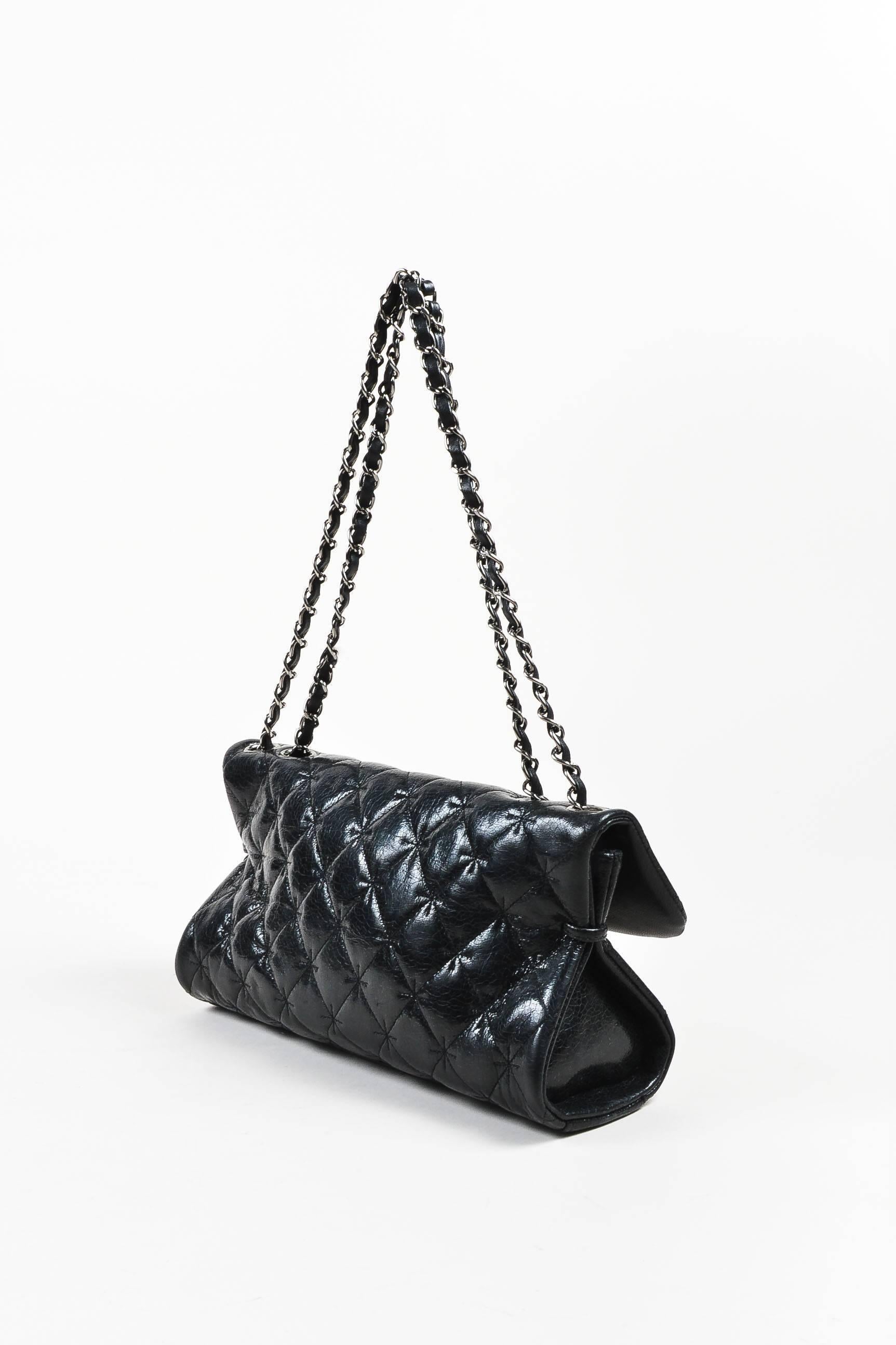Circa 2005-2006 Chanel east-west shoulder bag in glazed black crackled leather. Crosshatch stitching detailing on classic diamond-quilting. Silver-tone metal accents and hardware. Doubled curb-chain shoulder straps with leather interlaced