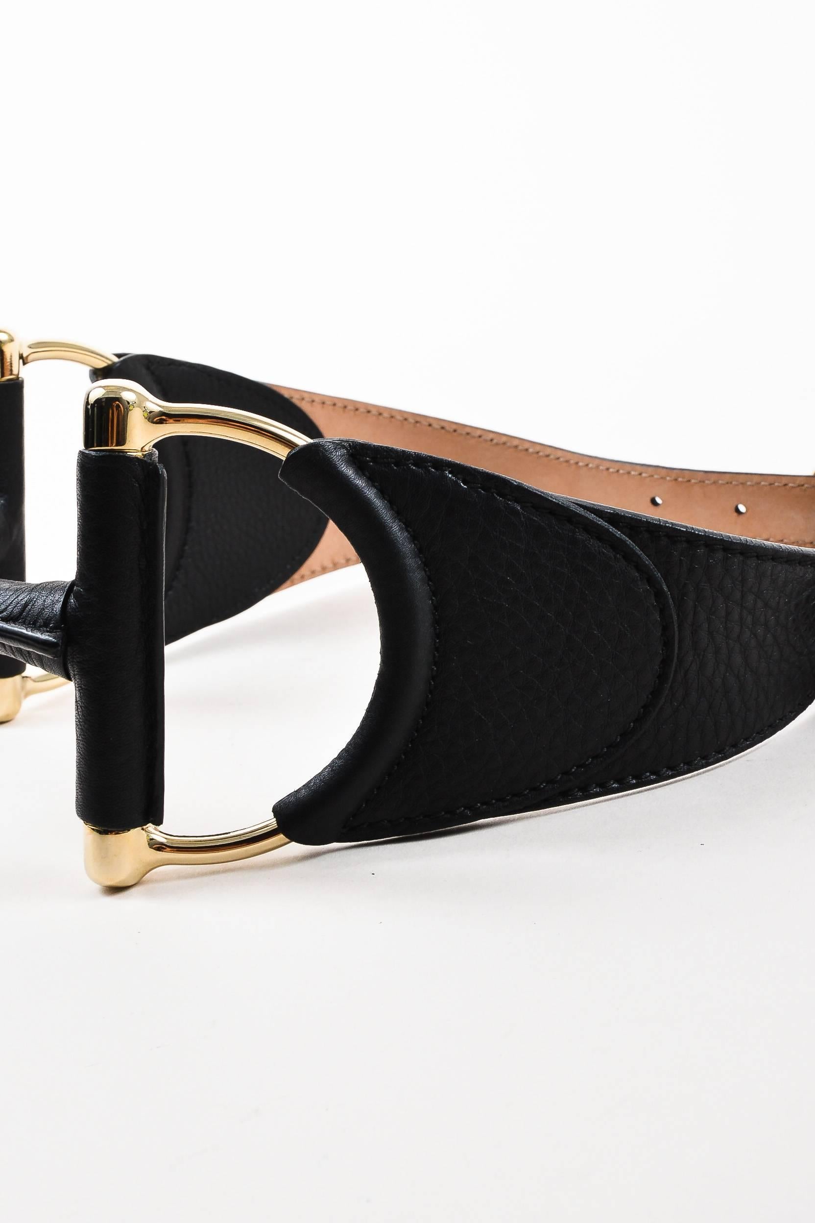 Black belt. Constructed of leather. Metallic gold-tone horsebit and hardware. Model/serial #: 245877-1766

Size: 65/26