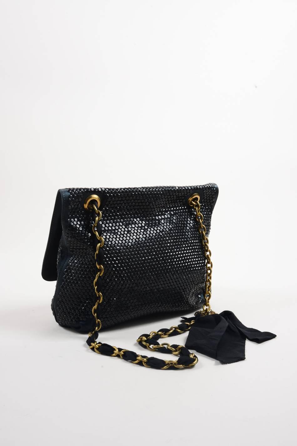 Retails for $4,459. Satchel bag is embellished throughout with black sequins. Secures with front turnlock closure. Gold tone metal and ribbon chain straps have two floral details, ribbon bow, and gold tone medallion. Straps can be worn as double, or