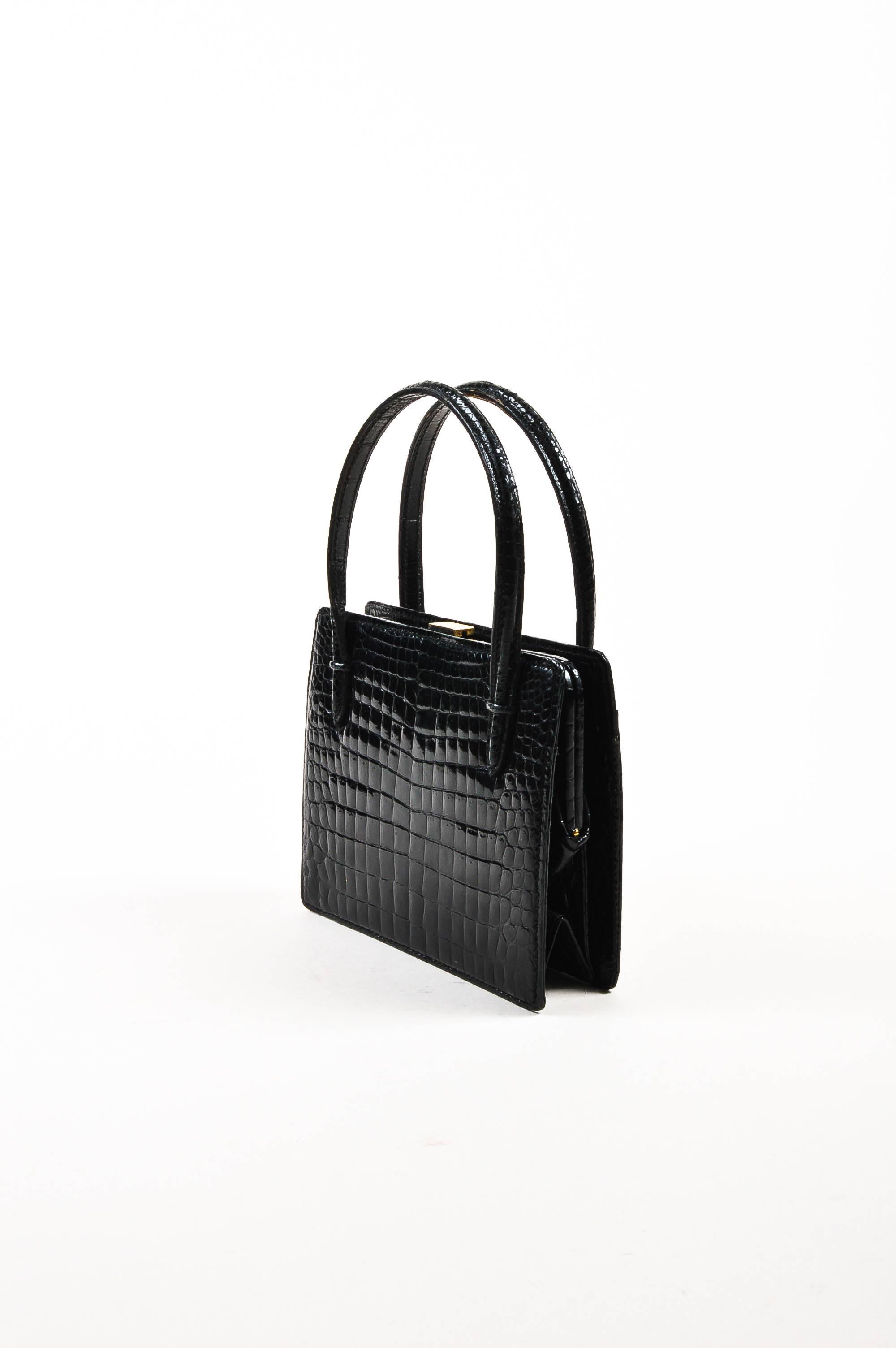 Comes in dust bag. Vintage Gucci bag has a structured shape and is constructed of black crocodile leather. Gold-tone push lock closure on top. Three exterior flat pockets. Two structured top handles.

Measurements:
Handle Length: