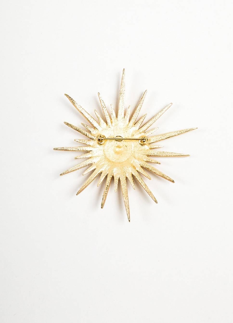 Comes with box. Flashy Chanel brooch from the 2001 Spring Collection. Pinned to a garment or worn on a scarf, this stunning piece adds instant glamour to any ensemble. Spiked starburst design. Gold tone metal sparkling with pave set rhinestone