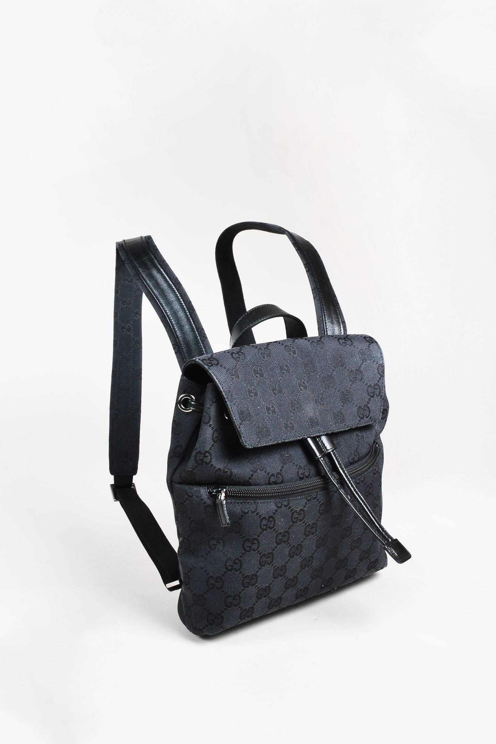 Released circa 1990s. Vintage backpack featuring a flat handle, flap front with a snap closure, a drawstring opening, 'GG' monogramming, and dual flat shoulder straps. Model/serial #: 003-0242-002058.

Interior feature: Single zipped wall