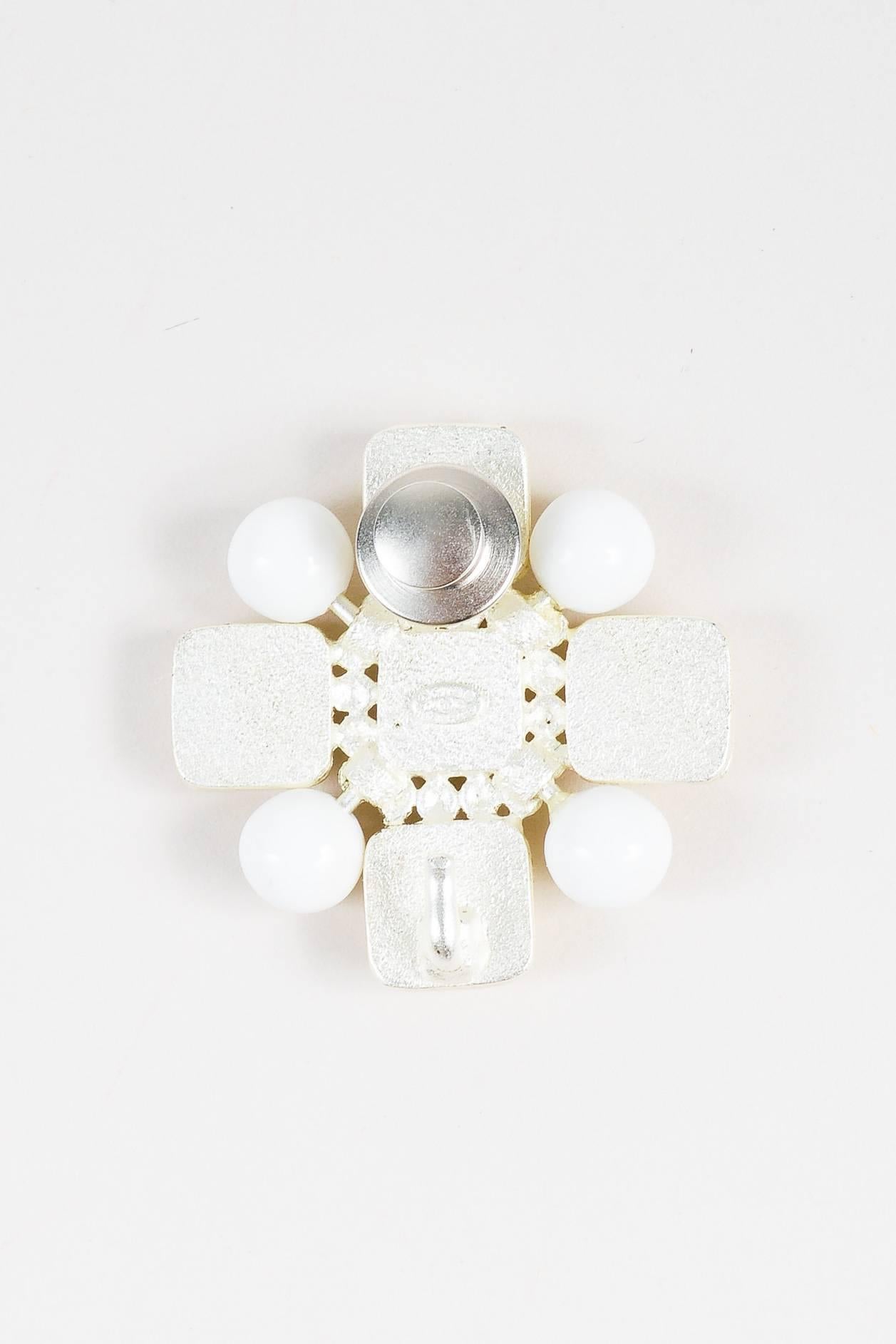Uniquely chic brooch from the cruise 2004 collection. Light gold-tone metal; metallic silver-tone finish. Glossy enamel cubes with hammered detail. Round resin accents. Center 'CC' logo. Back pin closure. Comes with box and original