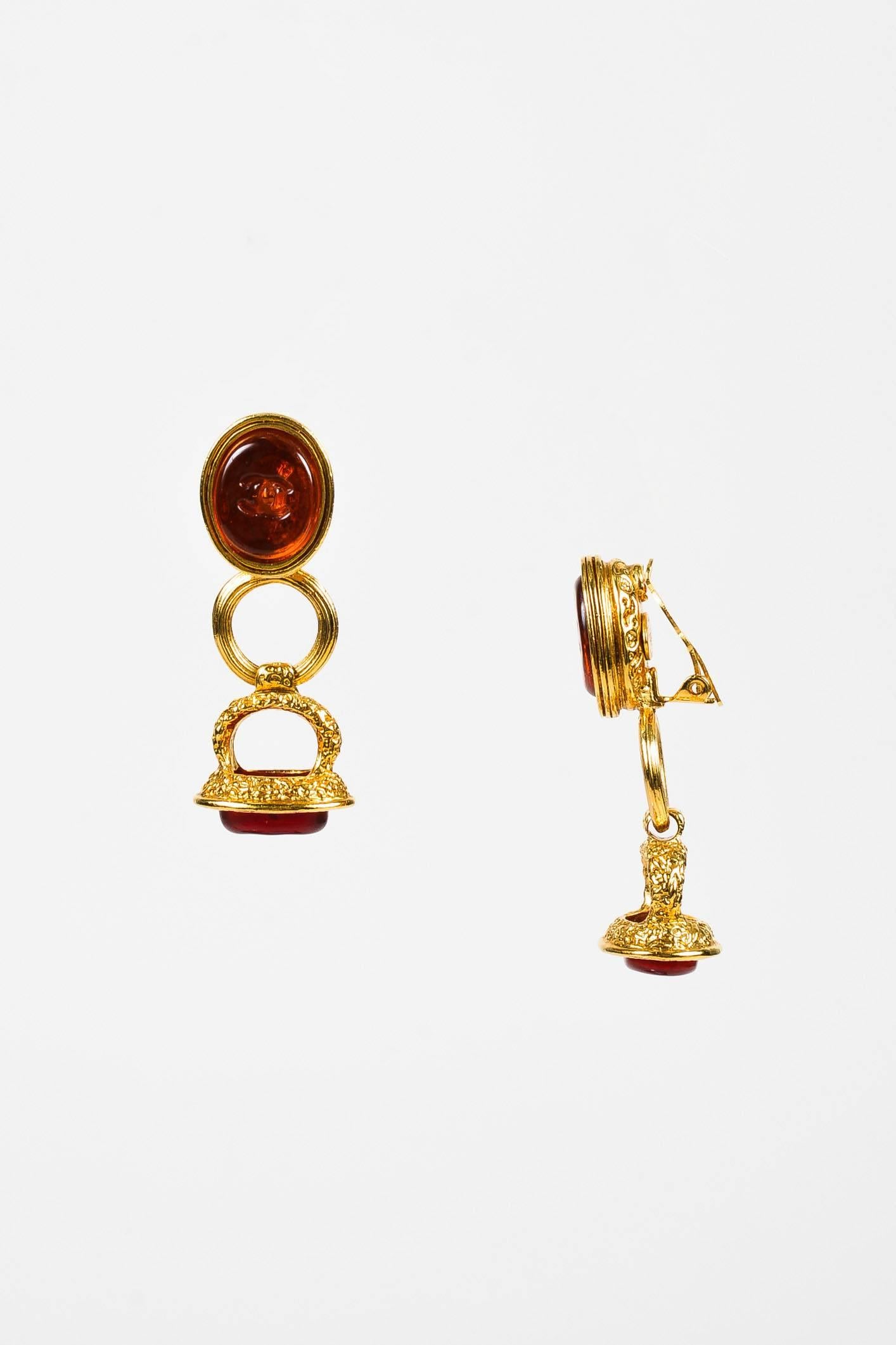 Made In: France
Fabric Content: Gold-Tone Metal, Gripoix

Item Specifics & Details: Gold-tone dangle clip on earrings from Chanel circa Fall 1993 Collection. Red gripoix embellishments feature embossed 'CC' logos.

Measurements:
Total