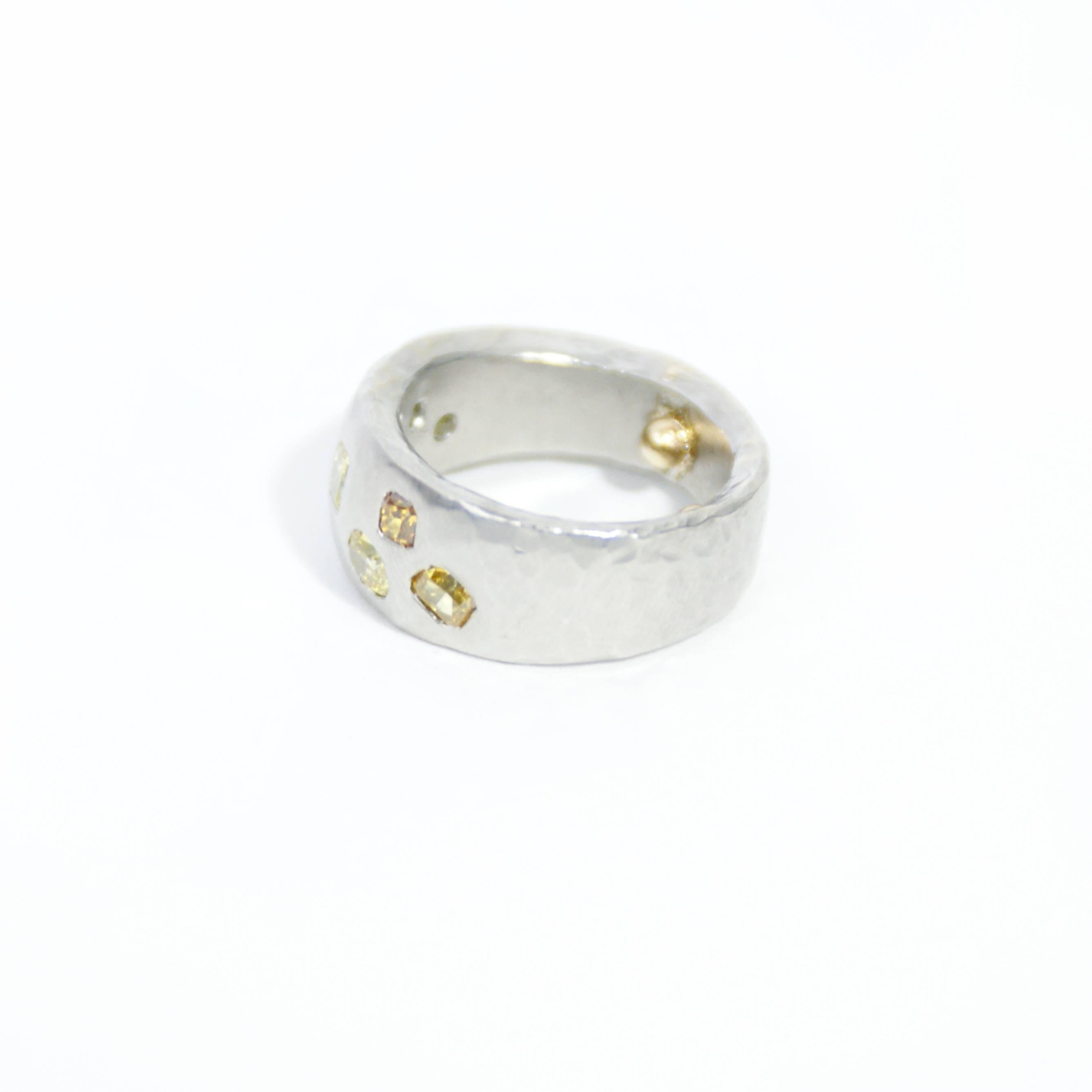 Insurance Appraisal as of January 20, 2016:

One platinum diamond band.  Stamped with the English hallmark of Platinum mad in London, The platinum band is set with seven yellow diamonds.  The band has a hammered finish and measures 7.30 mm-10.10 mm