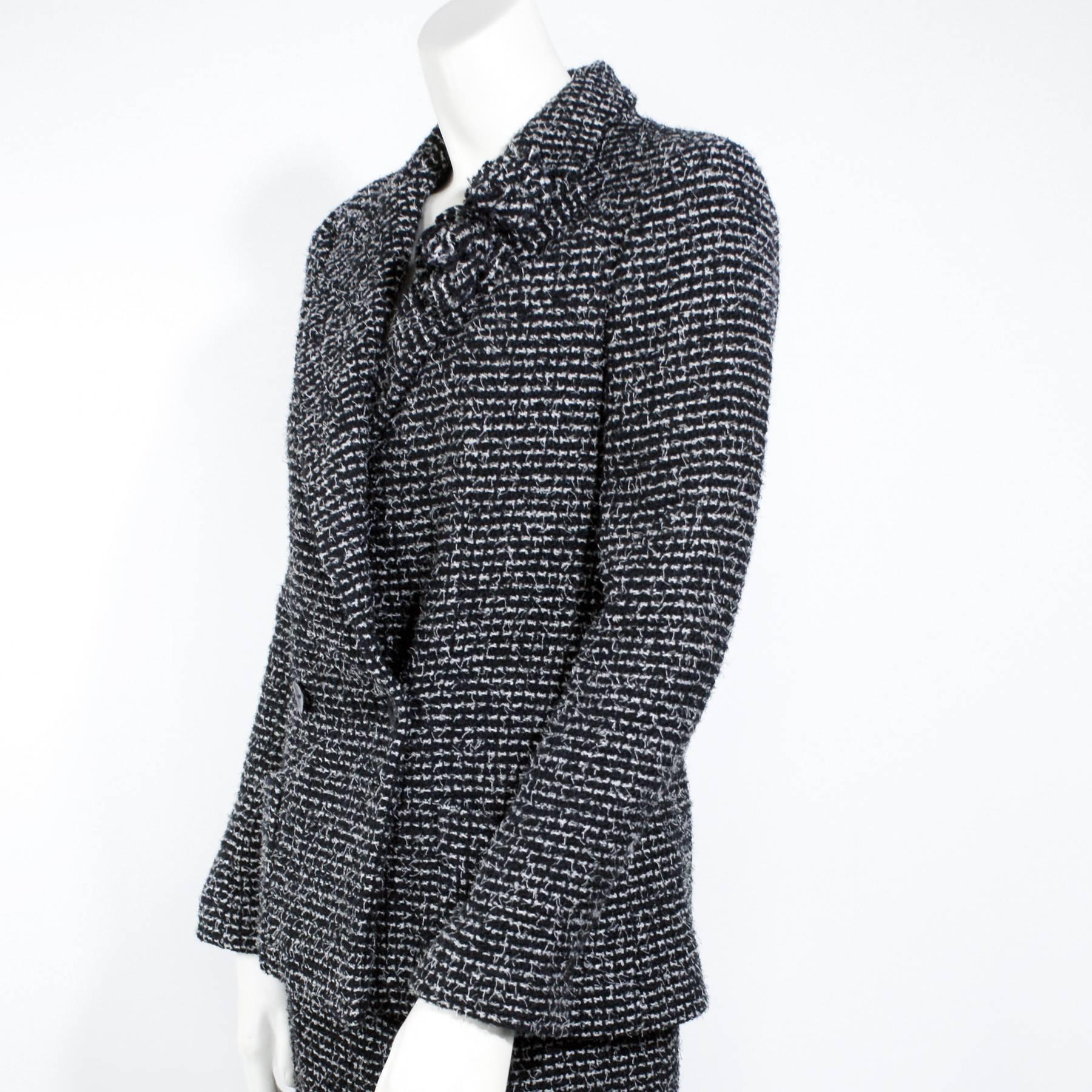 A classic Chanel skirt suit outfit
Crafted in wool
Black and White Tweed
Decorative floral detail at the collar
Two front pockets
Back zip closure on the skirt
"Chanel Paris" logos on the buttons. 
Euro Size 38
Original Price;