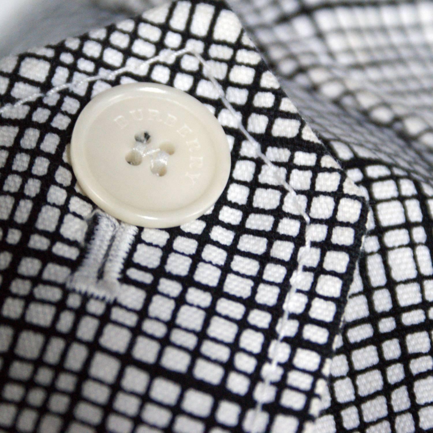 Black and white design
Cream logo buttons
Clasp closure at the neckline
