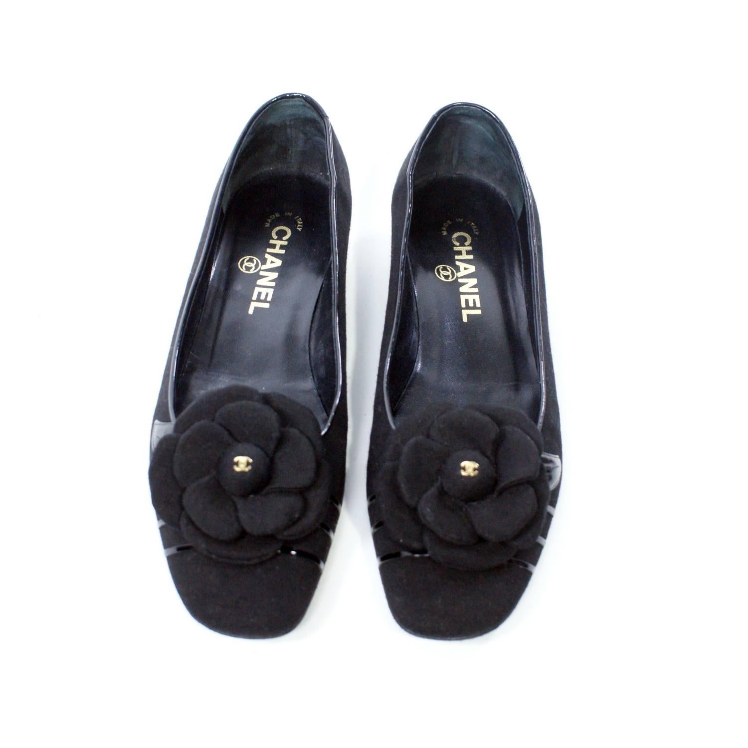 Black Flats with a very low heel 
Floral detail at the toe
Golden Chanel logos
