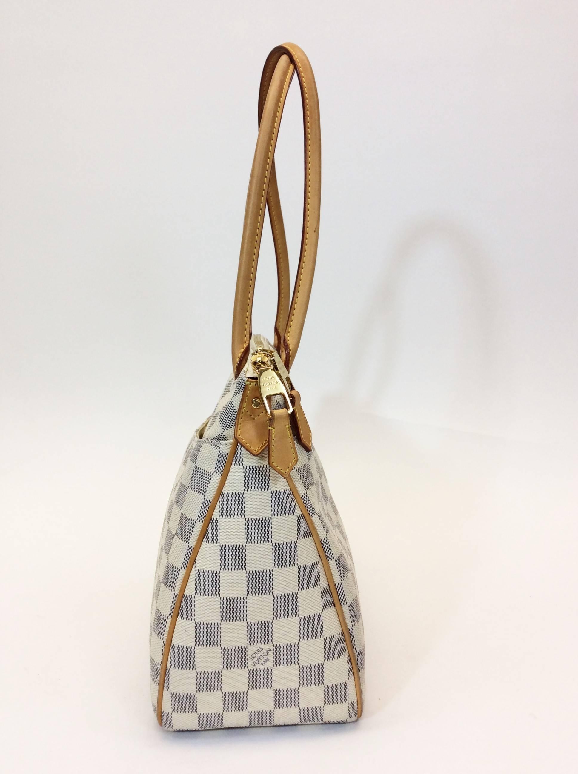 Louis Vuitton Damier Azur patterned Handbag
Cameltone Leather Shoulder Straps and Lining
Goldtone Zipper on Top for Closure
One Purse Width Pocket on Both sides
Two Smaller Pockets on Inside
Tan Canvas Interior
9.5