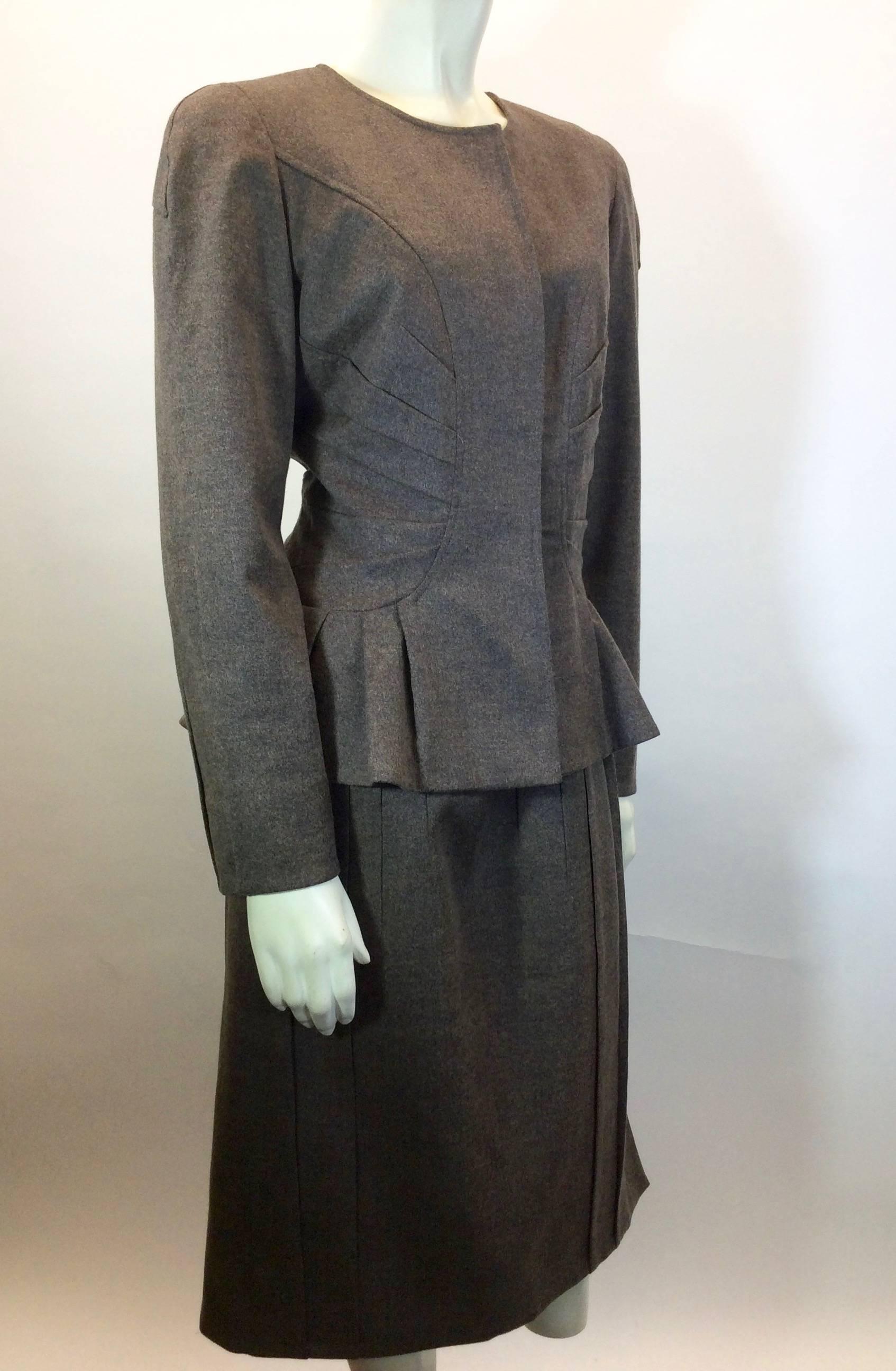 Brown and Tan Wool 
Pleating on Jacket Along Sides and Bottom 
Hidden Buttons on Jacket For Closure 
Pleating on Skirt
Hidden Zipper on back of Skirt 
Silk Interior on both Jacket and Skirt 
Skirt; Waist 33