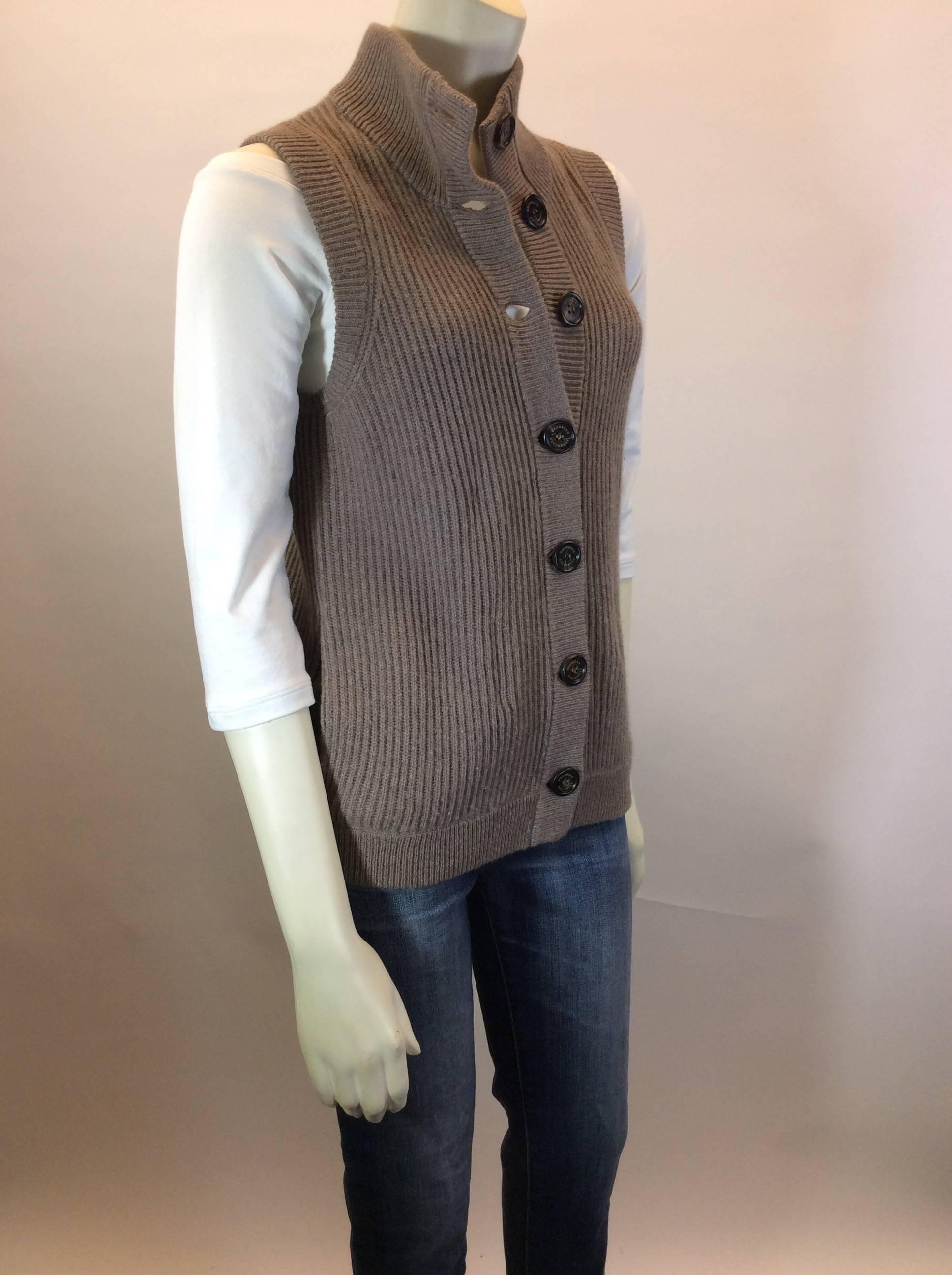 Light Tan/Brown 
Cable Knit Sleeveless Sweater 
100% Cashmere 
Dark Brown Buttons Along front for Closure 
One Single Pocket on Both Sides of Vest 