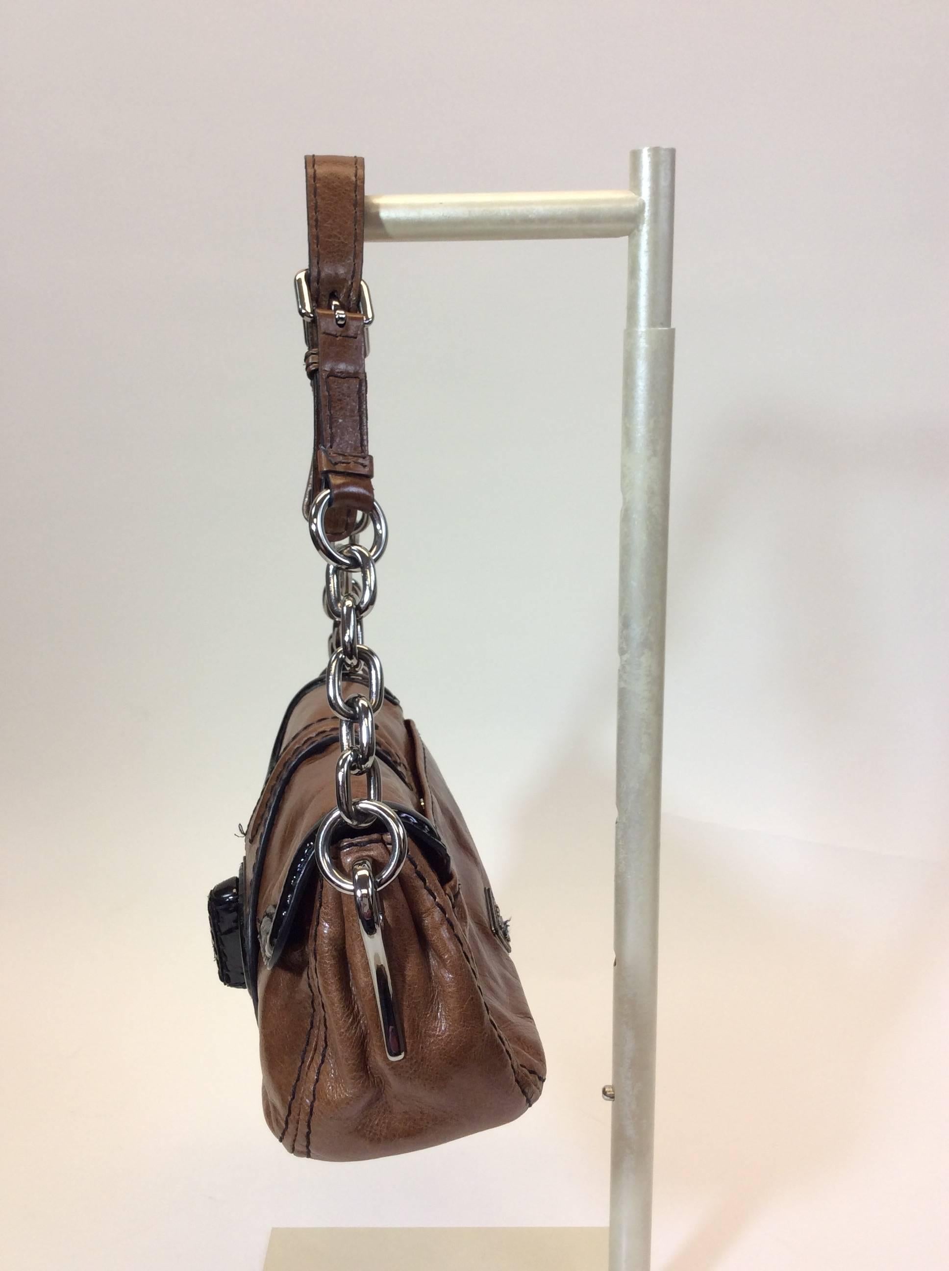Black Patent Leather Lock for Closure
SIlvertone Chain Strap
Genuine Leather
Prada Logo on Side
10