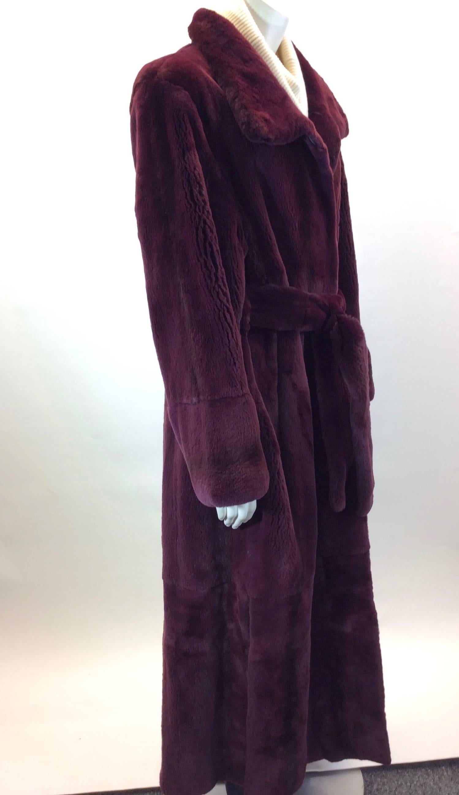 Burgundy Dyed Fur 
Sheared Mink 
Adjustable Wrap Belt 
Latches on front for Closure 
Two buttons near collar
Slits on bottom of Coat 
22” Inch Sleeve Length
New/Original Price: $13,500