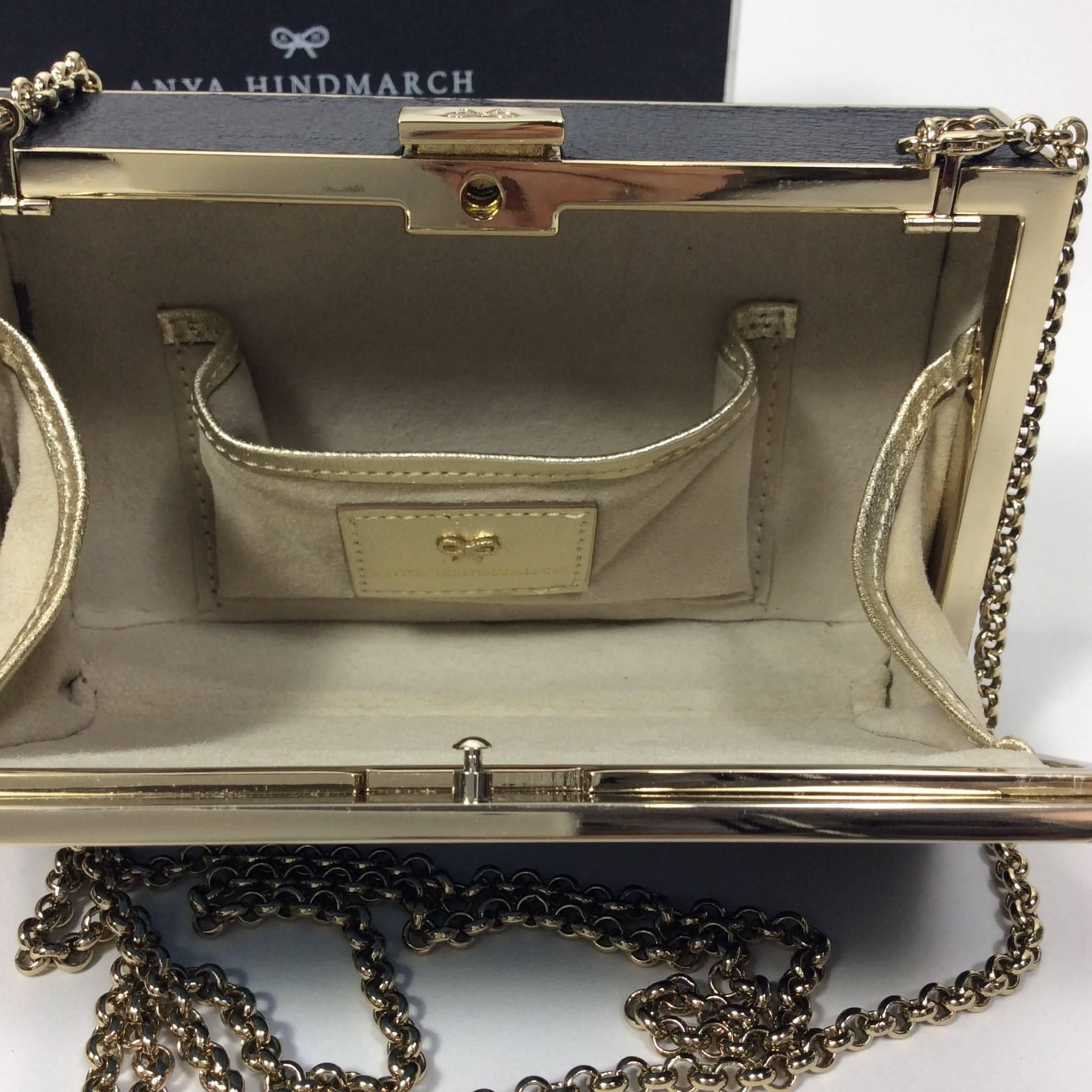 Anya Hindmarch Stop Staring at My Handbag Evening Clutch. The bag is inlaid with embossed leather trim and suede interior. The chain strap drop is 24